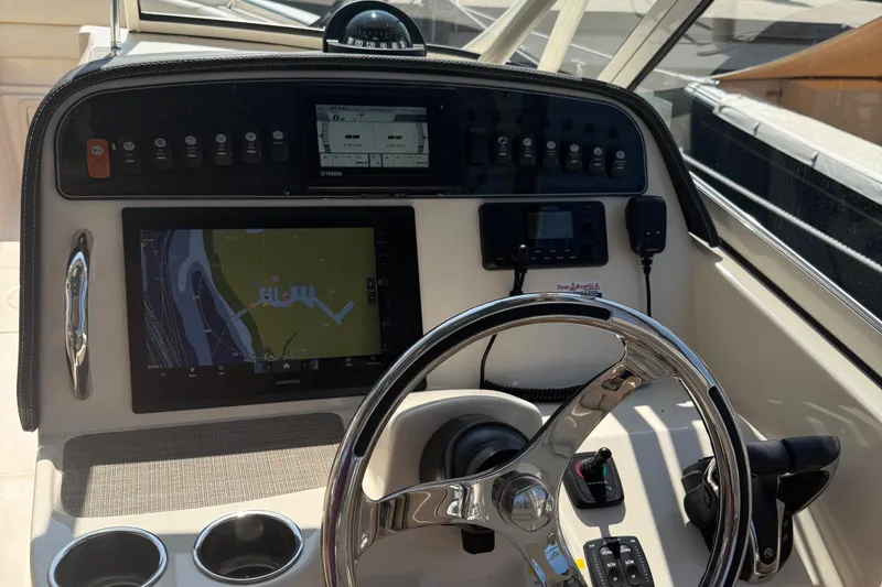 Slide: The Image of 2021 Grady-White Freedom 307 boat dashboard with navigation controls and steering wheel. - 8