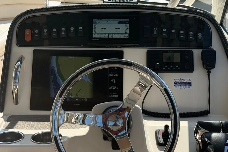 Slide: The Image of 2021 Grady-White Freedom 307 boat dashboard with steering wheel and navigation controls. - 9