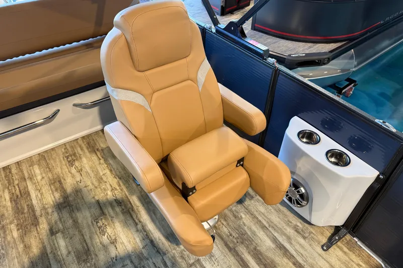 Slide: The Image of Luxurious tan captain's chair on 2024 Crest Caribbean LX 230 boat, with cup holders and speaker. - 16