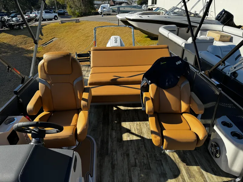 Slide: The Image of 2024 Crest Caribbean LX 230 pontoon boat displayed in a showroom with other boats. - 4