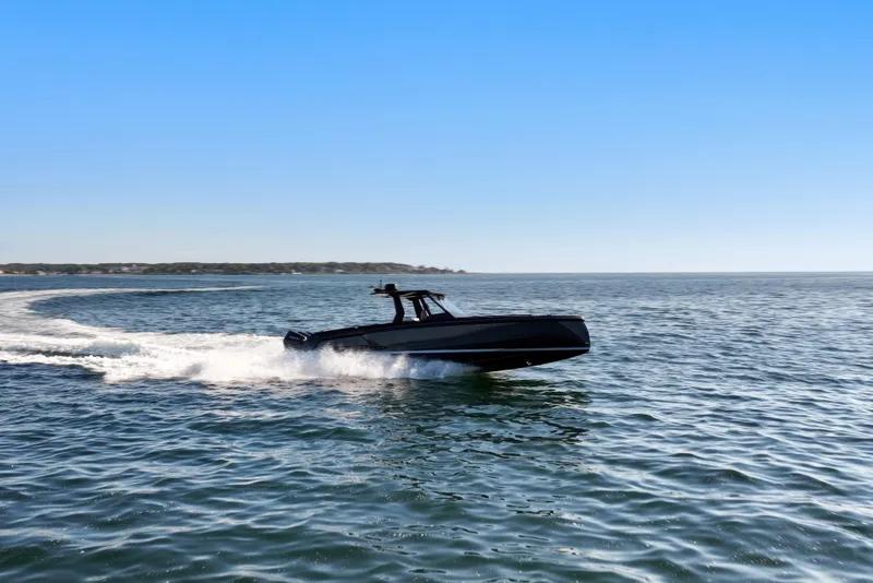 Slide: The Image of 2024 Vanquish Yachts VQ40 cruising on open water under clear blue sky. - 7