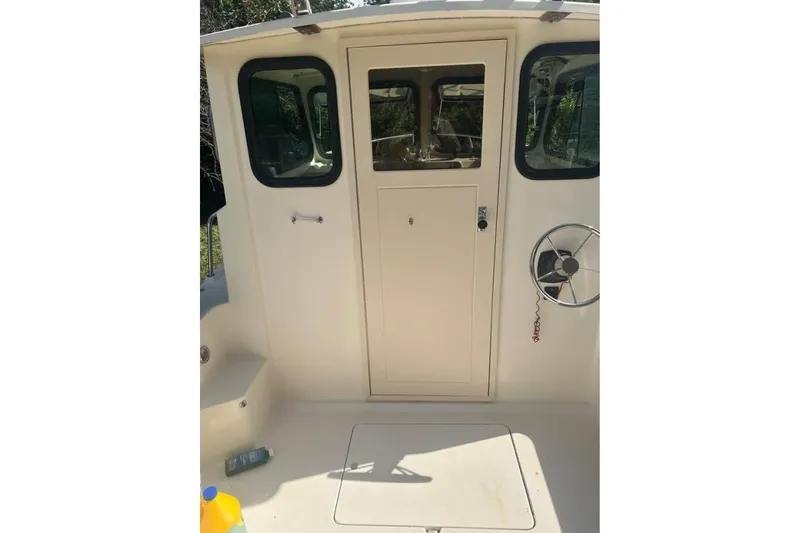 Slide: The Image of 2001 Parker 2320 Sport Cabin boat interior with steering wheel and cabin door. - 18