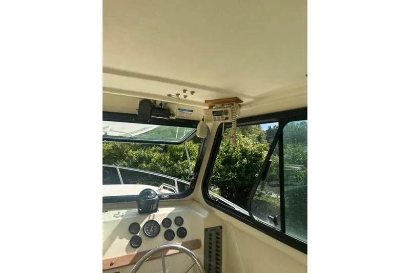 Slide: The Image of Interior view of 2001 Parker 2320 Sport Cabin boat with steering wheel and control panel. - 9