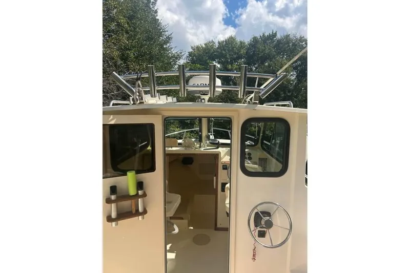 Slide: The Image of 2001 Parker 2320 Sport Cabin boat interior with steering wheel and cabin view. - 10