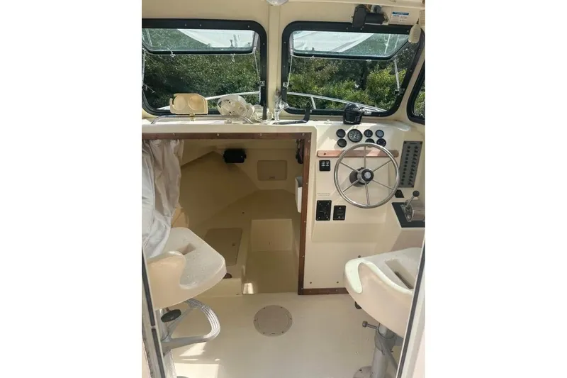 Slide: The Image of 2001 Parker 2320 Sport Cabin interior with steering wheel and dashboard controls. - 14