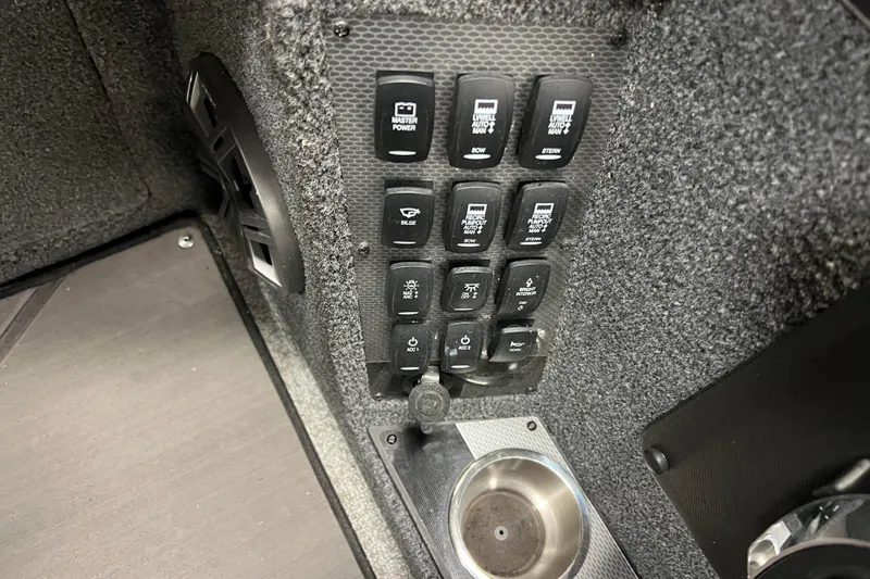 Slide: The Image of Control panel of 2023 Lund 2175 Pro-V boat with various switches and cup holder. - 10