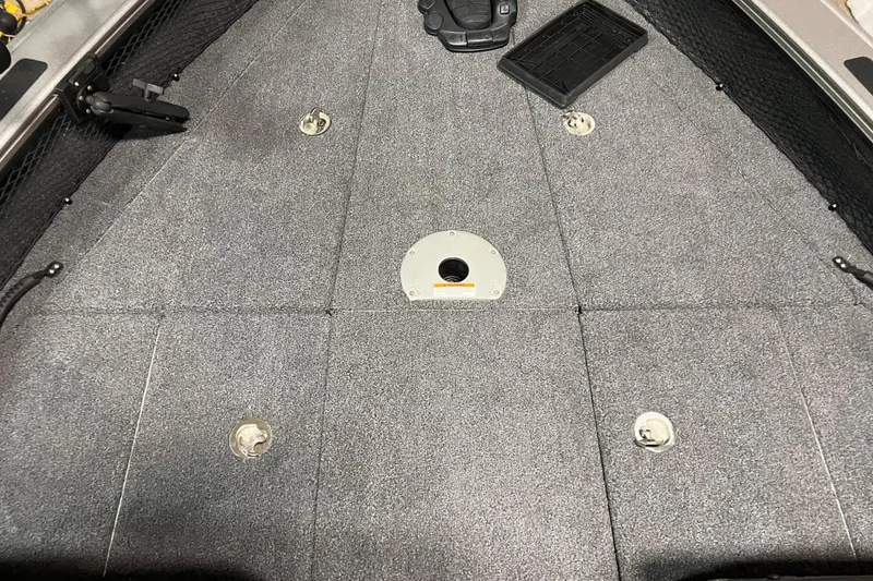 Slide: The Image of 2023 Lund 2175 Pro-V boat deck with gray carpet and storage compartments. - 16