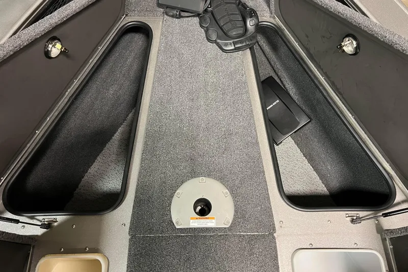 Slide: The Image of 2023 Lund 2175 Pro-V boat interior storage compartments, featuring carpeted surfaces and secure locks. - 20