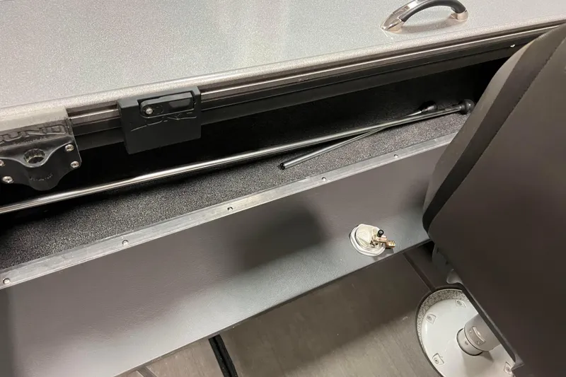 Slide: The Image of 2023 Lund 2175 Pro-V boat interior storage compartment with handle and lock mechanism. - 35