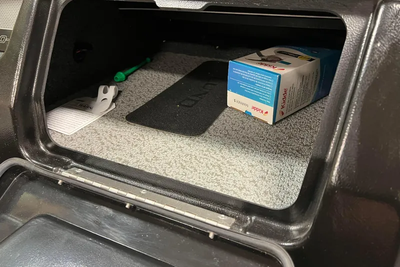 Slide: The Image of 2023 Lund 2175 Pro-V storage compartment with Kidde box and green pen. - 38