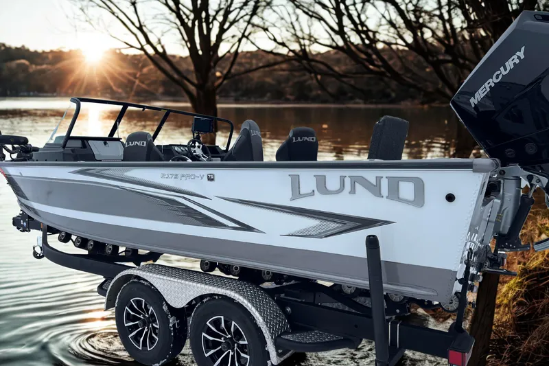 Slide: The Image of 2023 Lund 2175 Pro-V boat on trailer by lake at sunset. - 4