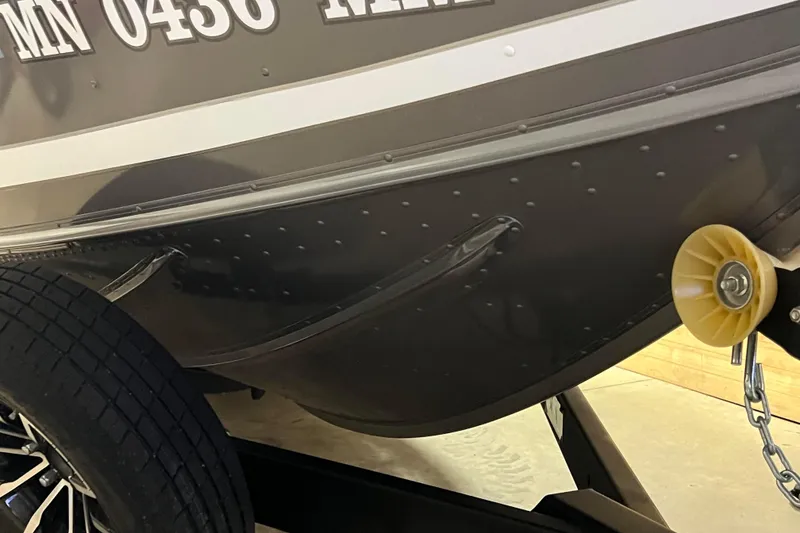 Slide: The Image of 2023 Lund 2175 Pro-V boat on trailer, close-up of hull and wheel. - 52