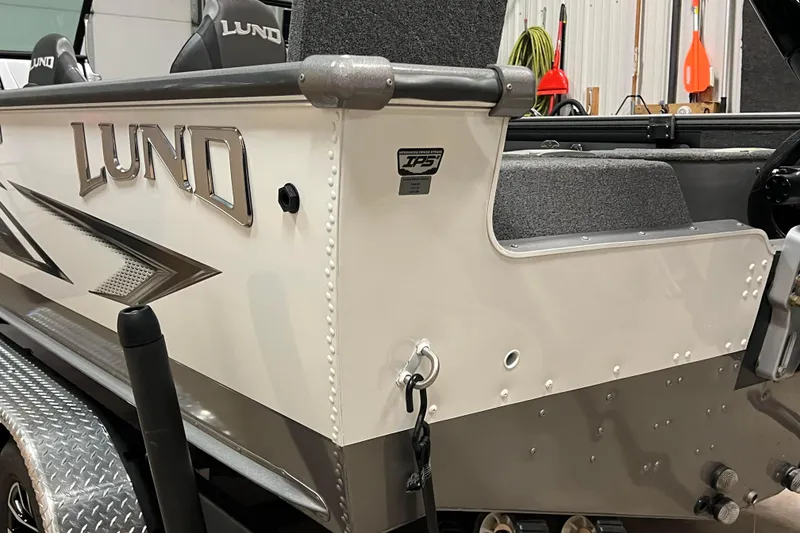 Slide: The Image of 2023 Lund 2175 Pro-V boat, side view, showcasing sleek design and branding. - 66