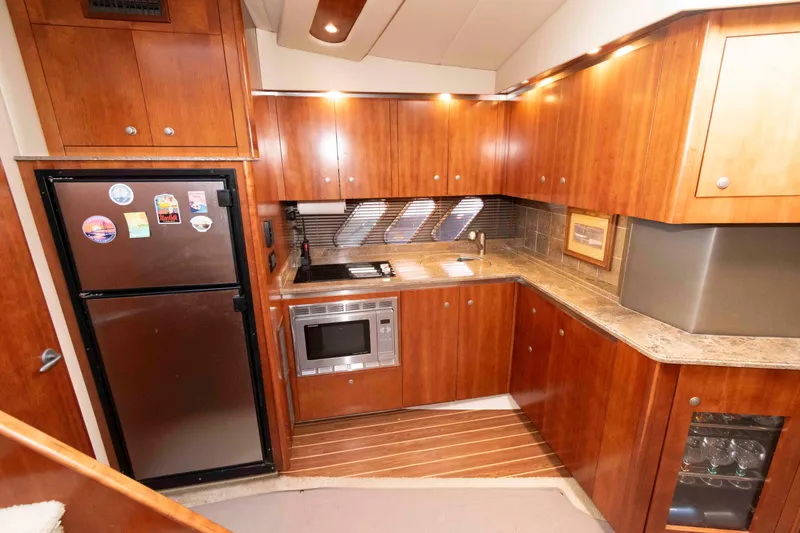 Slide: The Image of Luxurious 2008 Cruisers Yachts 460 Express kitchen with wood cabinetry and modern appliances. - 12