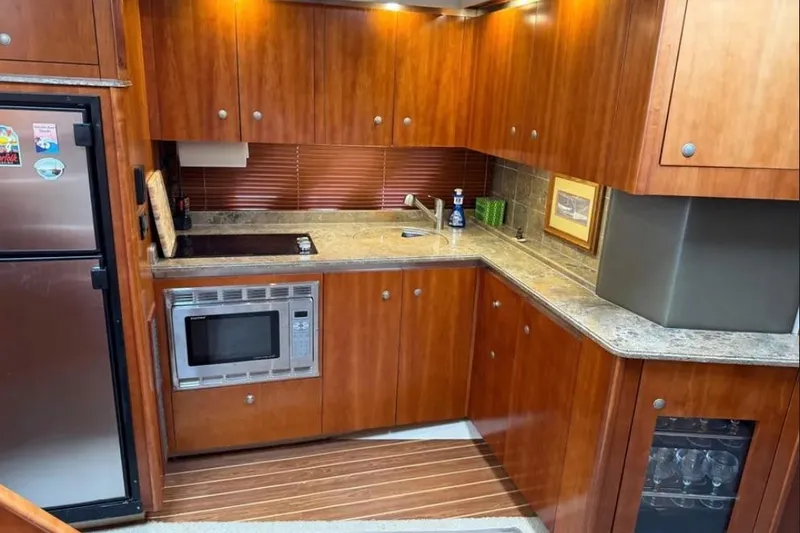Slide: The Image of Luxurious 2008 Cruisers Yachts 460 Express kitchen with wood cabinetry and modern appliances. - 5