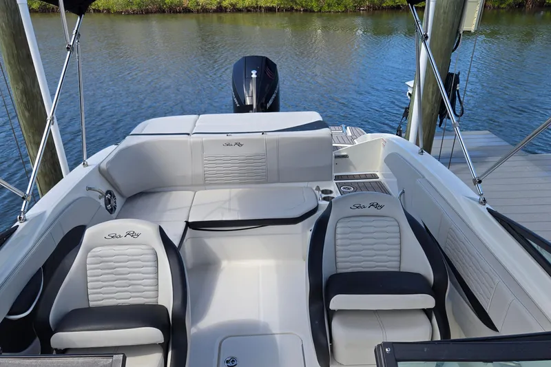Slide: The Image of 2023 Sea Ray SPX 210 boat interior with stylish seating and water backdrop. - 17