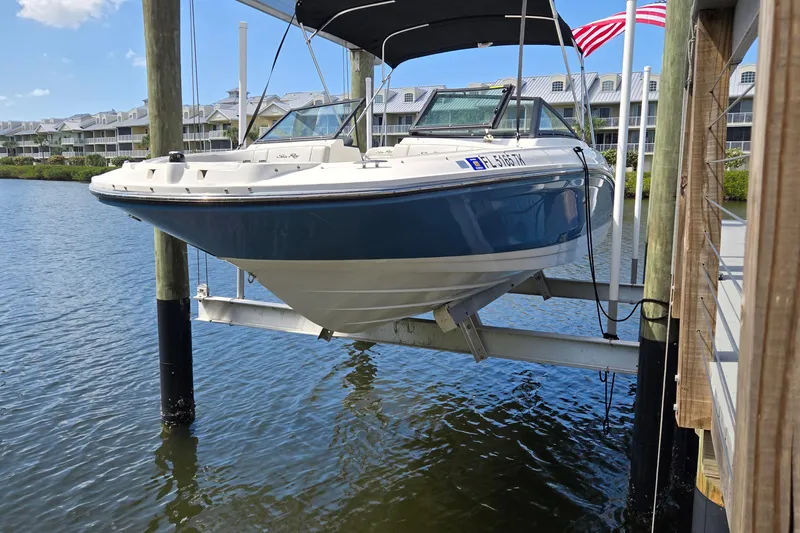 Slide: The Image of 2023 Sea Ray SPX 210 boat on lift, docked by waterfront homes. - 23