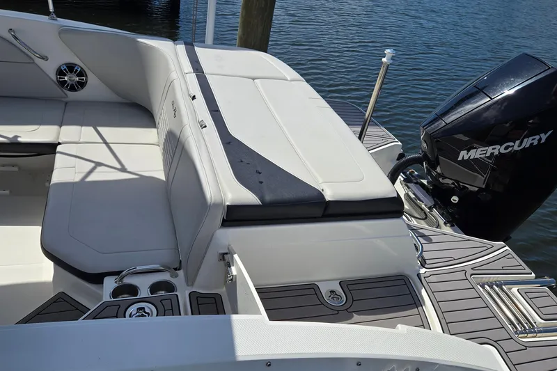 Slide: The Image of 2023 Sea Ray SPX 210 boat interior with Mercury engine, featuring comfortable seating and cup holders. - 27
