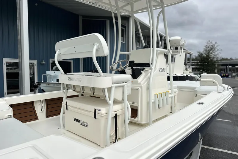 Slide: The Image of 2026 Pathfinder 2200 TRS boat with seating and storage, docked outdoors. - 22