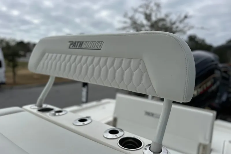 Slide: The Image of 2026 Pathfinder 2200 TRS boat seat with logo, featuring white upholstery and cup holders. - 8