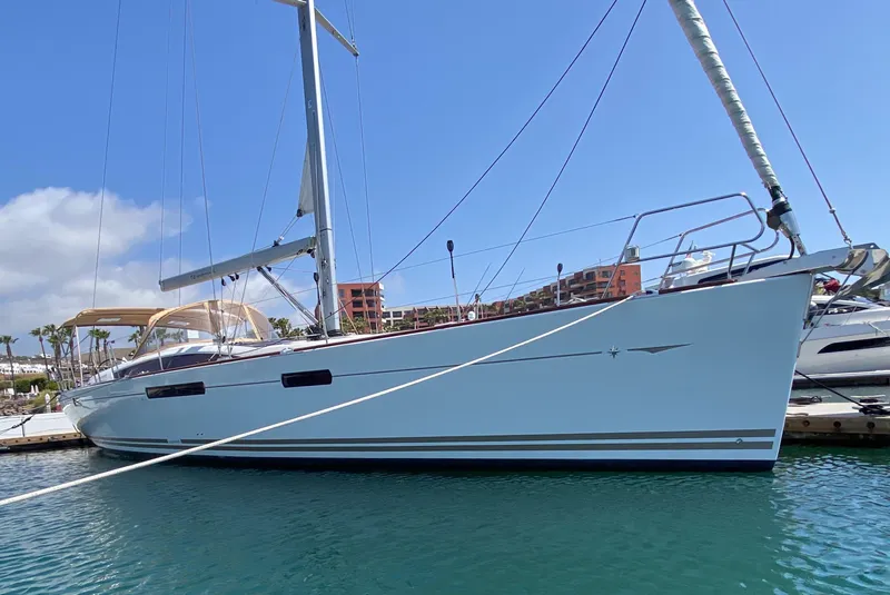 Slide: The Image of 2014 Jeanneau 57 yacht docked in marina under clear blue sky. - 10
