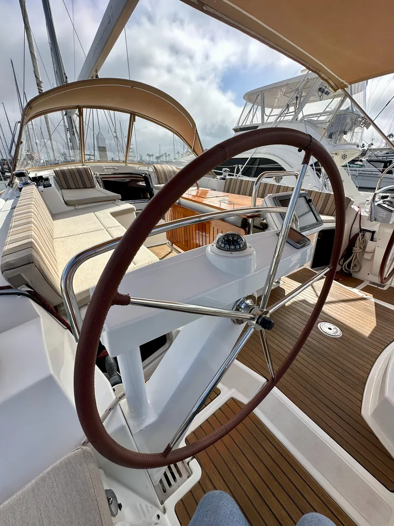Slide: The Image of 2014 Jeanneau 57 yacht cockpit with steering wheel and seating area. - 28