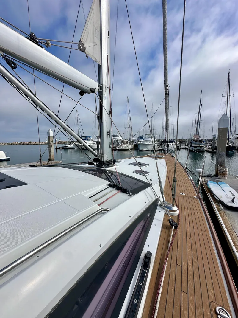 Slide: The Image of 2014 Jeanneau 57 sailboat docked at marina, showcasing deck and mast. - 40