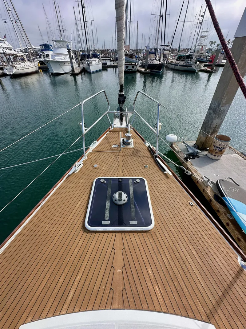 Slide: The Image of 2014 Jeanneau 57 yacht docked in marina, showcasing teak deck and sleek design. - 43