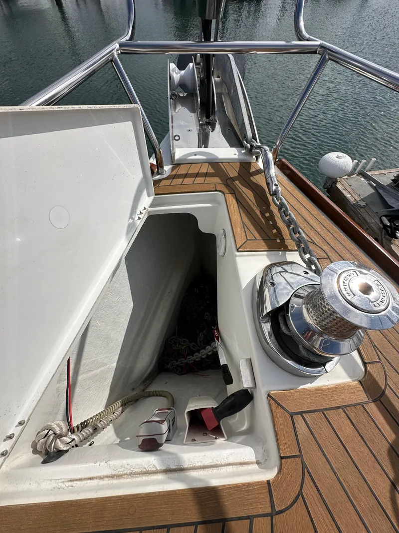 Slide: The Image of 2014 Jeanneau 57 yacht deck with open storage compartment and winch. - 49