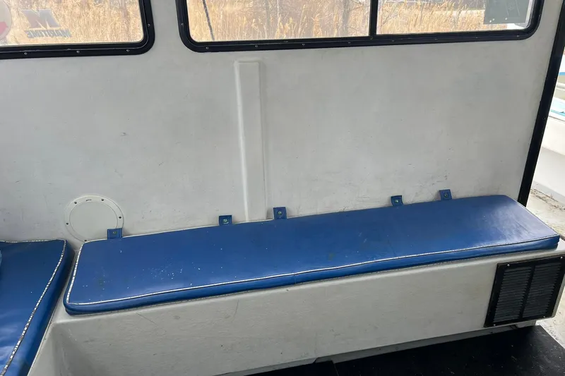 Slide: The Image of Interior of 1985 Young Brothers 40 boat with blue cushioned seating. - 13