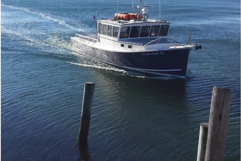 Slide: The Image of Young Brothers 40 boat, 1985 model, cruising on calm blue water near wooden posts. - 4