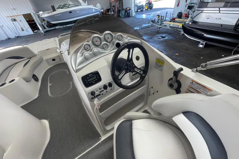 Slide: The Image of Interior view of a 2016 Starcraft Coastal 2009 OB boat, featuring steering console and seating. - 10