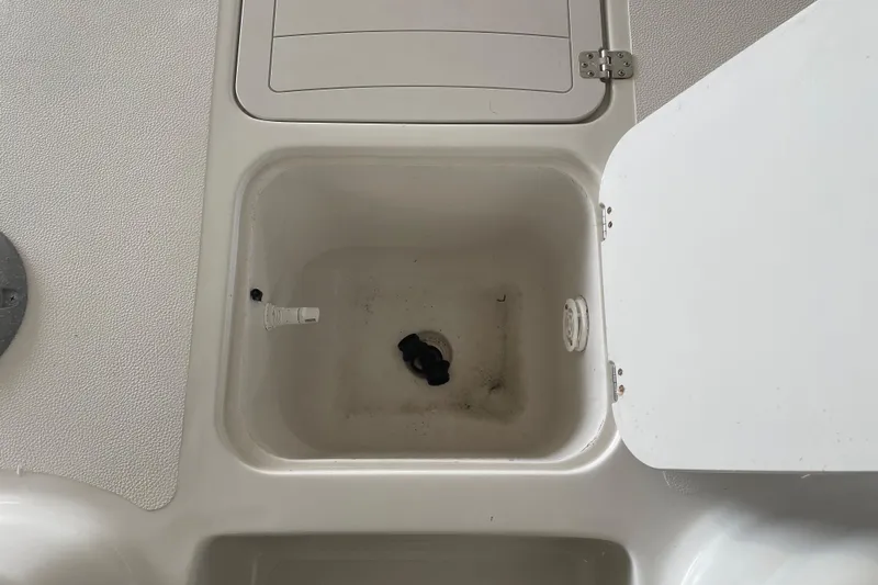 Slide: The Image of Starcraft Coastal 2009 OB 2016 boat compartment with open hatch and visible drain. - 15