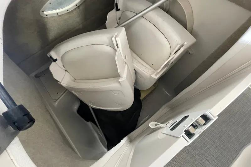 Slide: The Image of Interior of a 2016 Starcraft Coastal 2009 OB boat showing storage compartment with white seats. - 8