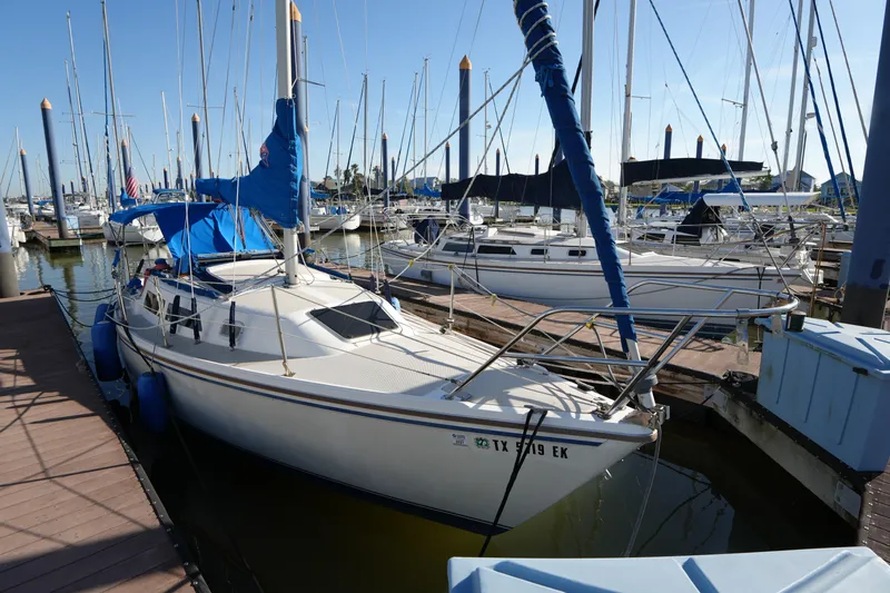 The Image of 1988 Catalina 27 sailboat docked in a marina, surrounded by other boats. - 0