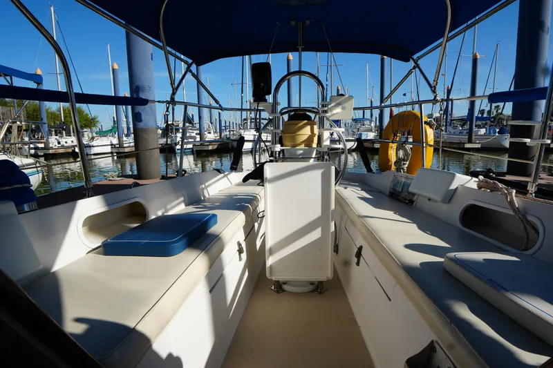 Slide: The Image of Cockpit of a 1988 Catalina 27 sailboat docked at a marina under blue skies. - 11