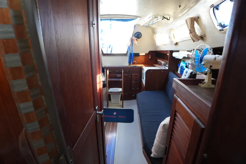 Slide: The Image of Interior of a 1988 Catalina 27 sailboat with wooden cabinetry and seating area. - 14