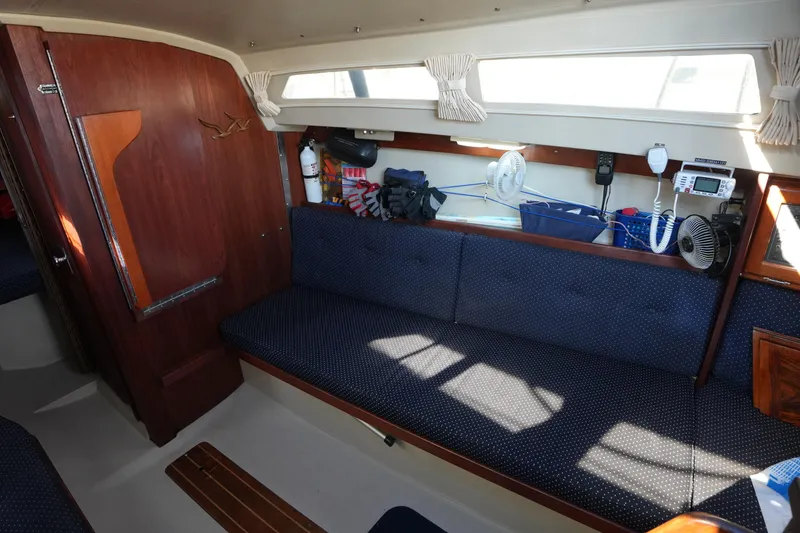 Slide: The Image of Interior of a 1988 Catalina 27 sailboat with blue cushioned seating. - 16