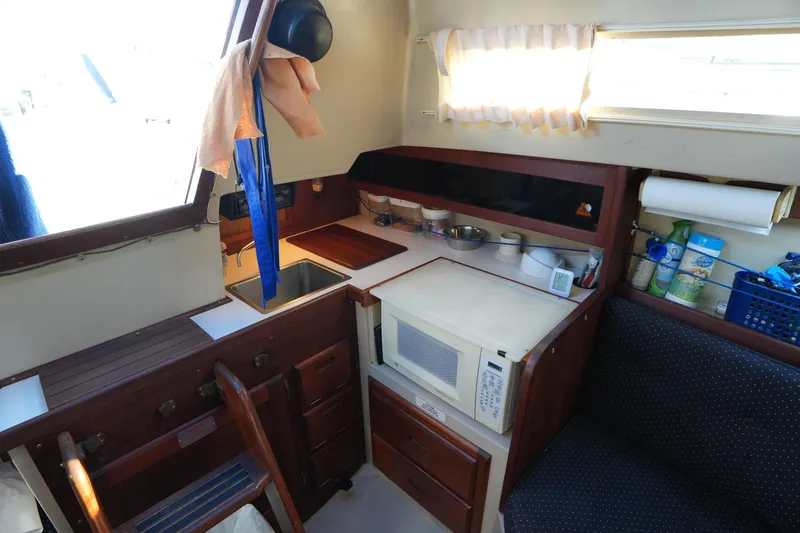 Slide: The Image of Interior of a 1988 Catalina 27 sailboat galley with sink, microwave, and storage. - 18