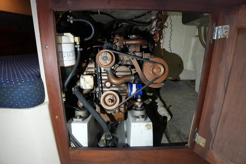 Slide: The Image of Engine compartment of a 1988 Catalina 27 sailboat, showcasing mechanical components and belts. - 21