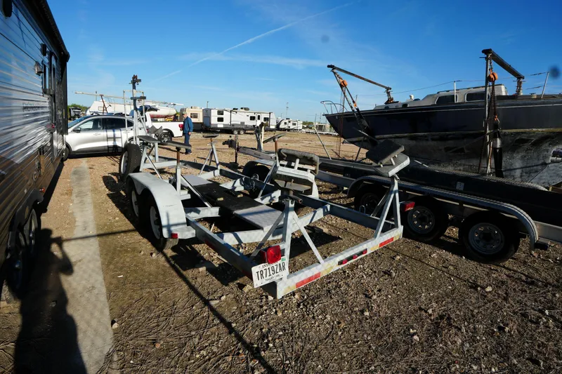 Slide: The Image of Trailer and boats in a storage yard under clear blue sky. - 24