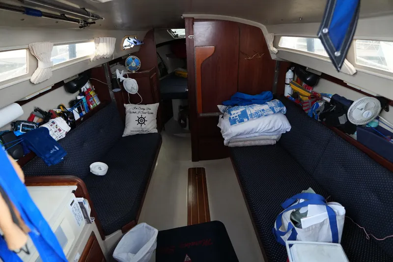 Slide: The Image of 1988 Catalina 27 sailboat docked at marina with American flag and blue canopy. - 3