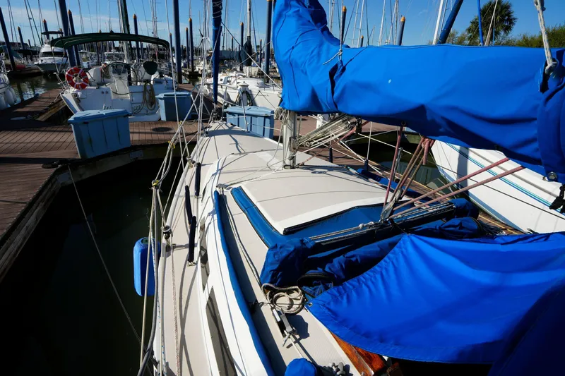 Slide: The Image of 1988 Catalina 27 sailboat docked at marina with blue sail covers. - 6