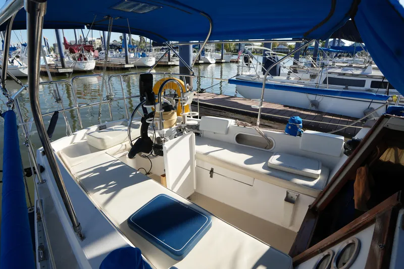 Slide: The Image of 1988 Catalina 27 sailboat cockpit with blue canopy, docked in a marina. - 8