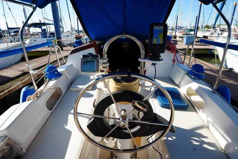 Slide: The Image of Cockpit of a 1988 Catalina 27 sailboat with navigation equipment and marina view. - 9