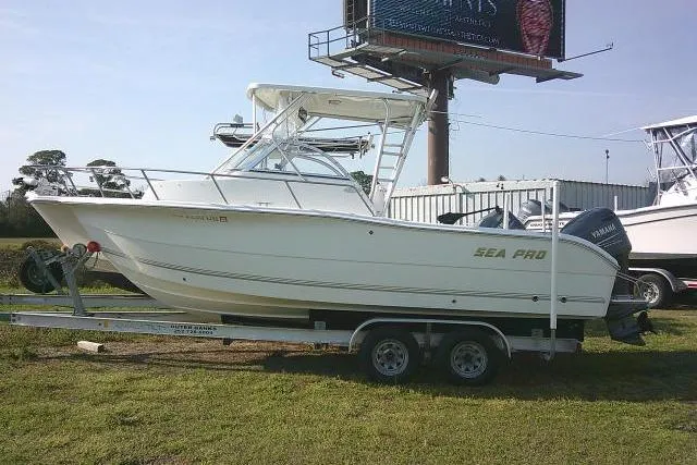 The Image of 2005 Sea Pro boat on trailer, parked outdoors near billboard. - 1