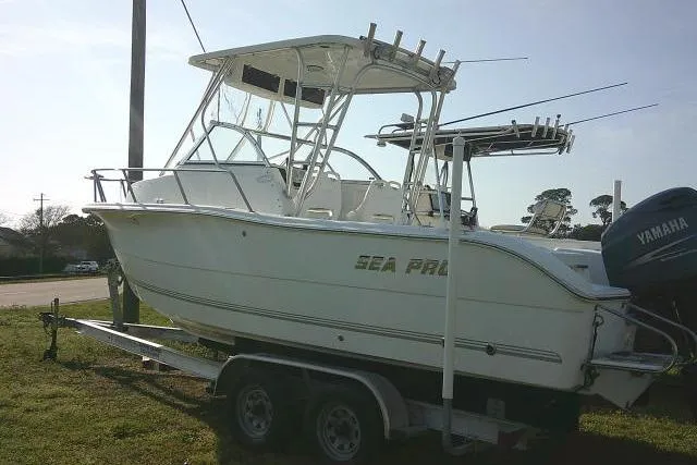Slide: The Image of 2005 Sea Pro boat on trailer with Yamaha outboard motor, parked on grass. - 17