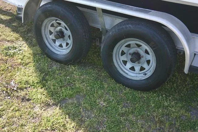 Slide: The Image of 2005 Sea Pro trailer wheels on grass, featuring dual tires and metal rims. - 18