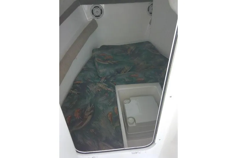 Slide: The Image of 2005 Sea Pro boat cabin interior with patterned cushions and storage compartment. - 21