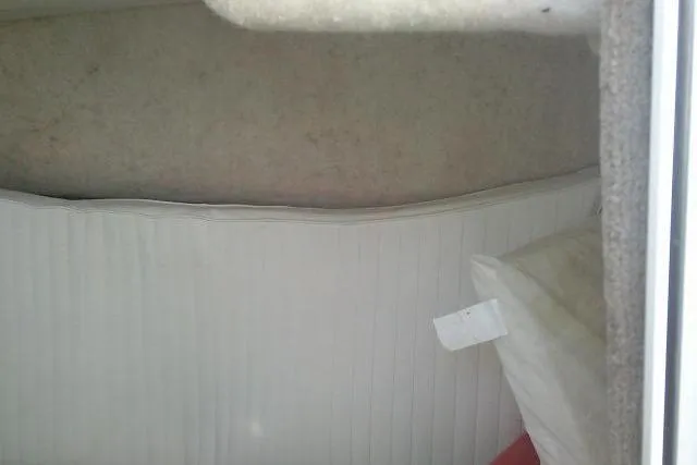 Slide: The Image of 2005 Sea Pro boat interior with white cushioned seating and storage area. - 23